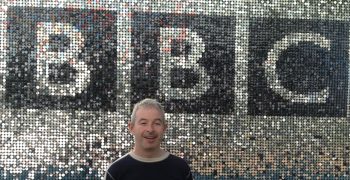Garry Green standing in front of a large sparkly BBC sign.